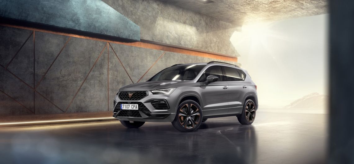 Frontansicht des CUPRA Ateca INICIO mit seinem auffallenden Äusseren in Graphite Grey vor einer architektonischen Kulisse.