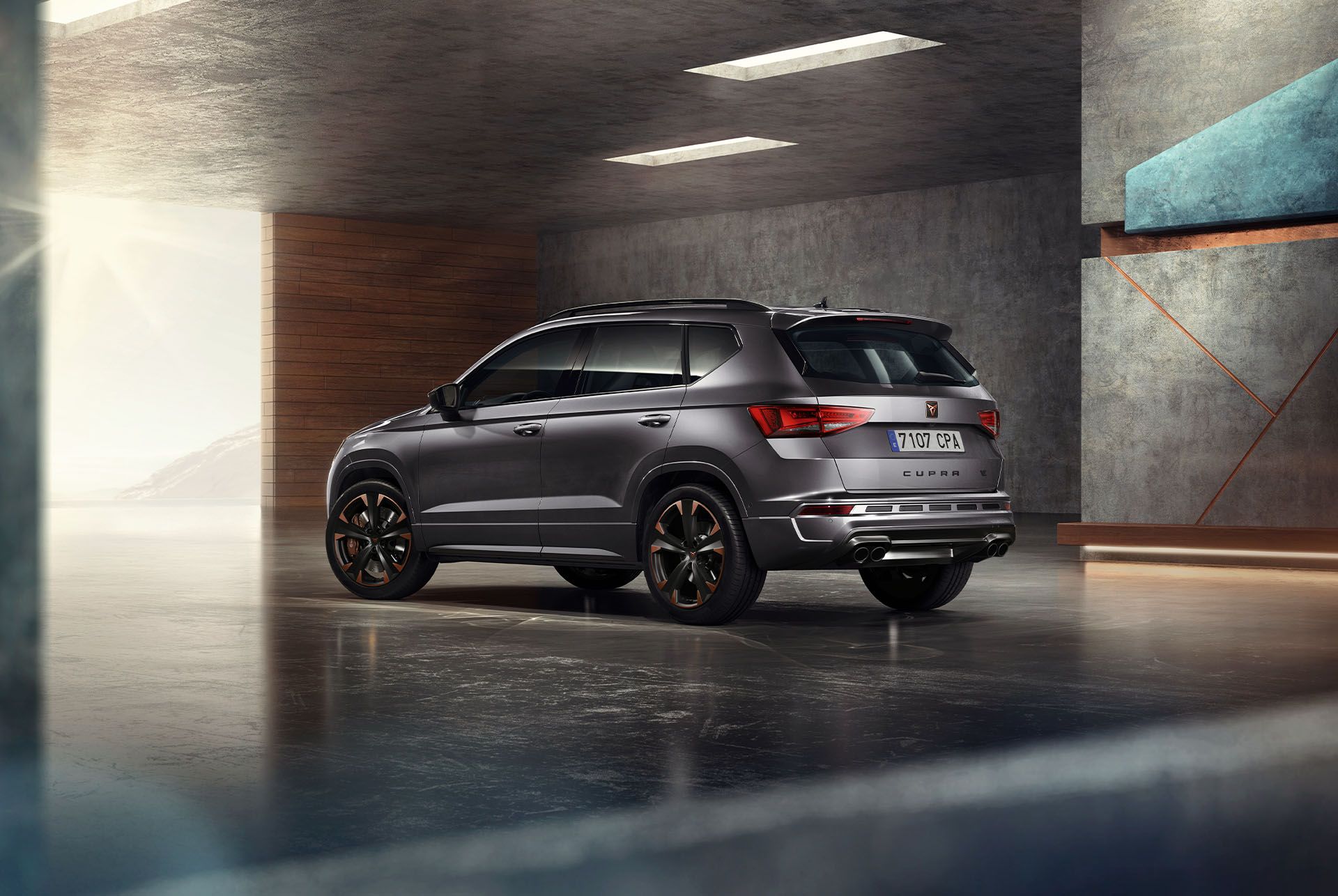 Ein grauer CUPRA Ateca SUV wird auf weissem Hintergrund abgebildet. Der markante Kühlergrill, die LED-Scheinwerfer und die Leichtmetallräder mit Kupferakzenten unterstreichen das sportliche Design des Fahrzeugs.