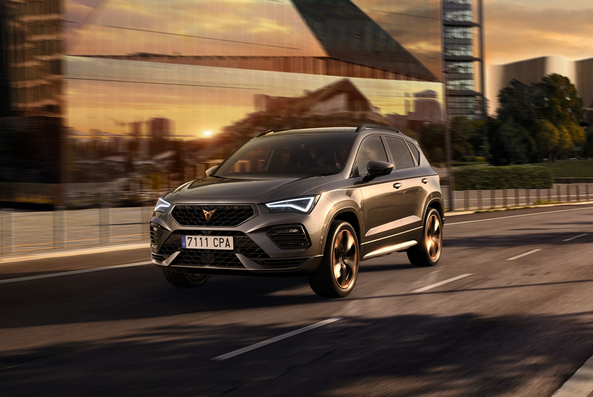 Ein grauer CUPRA Ateca SUV wird auf weissem Hintergrund abgebildet. Der markante Kühlergrill, die LED-Scheinwerfer und die Leichtmetallräder mit Kupferakzenten unterstreichen das sportliche Design des Fahrzeugs.