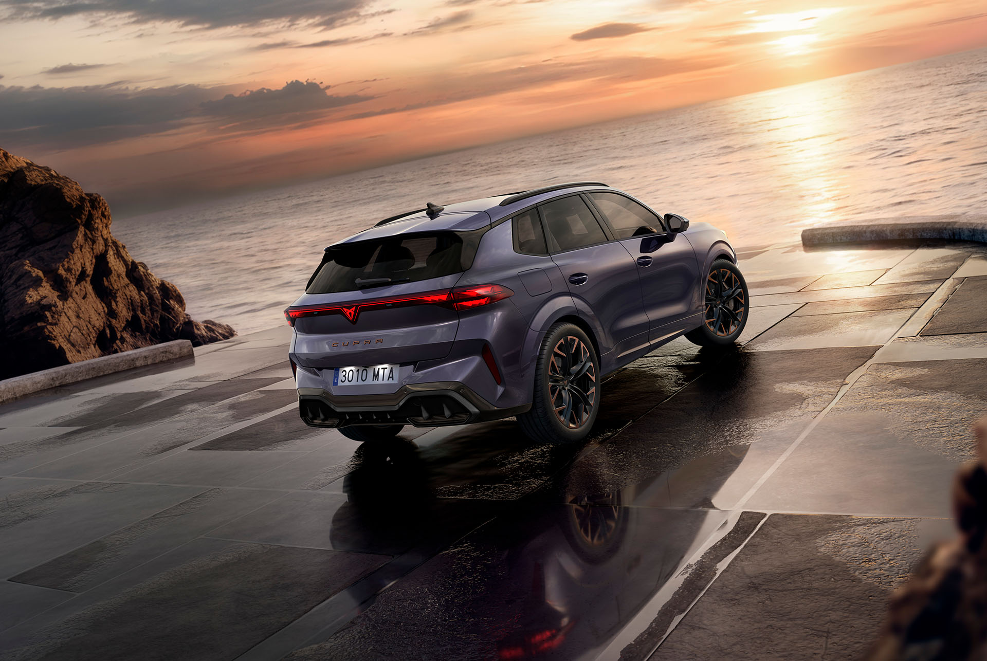 Vue arrière de la CUPRA Terramar 2024 avec moteur e-HYBRID, feux HD, DCC Sport, jantes «Hadron Copper» 20", intérieur «High Canyon» et feux arrière 3D avec logo CUPRA, au coucher du soleil.