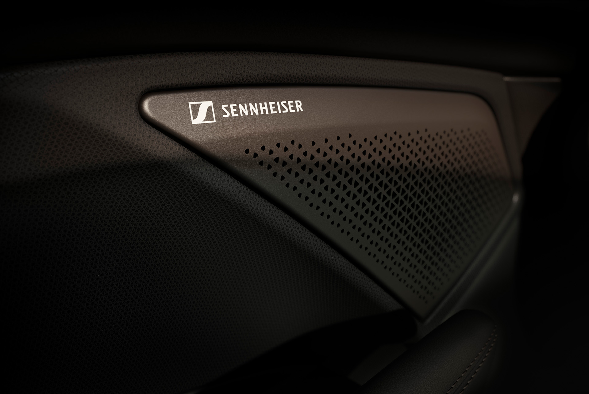 Immersive by Sennheiser: Impianto audio Hi-Fi con 12 altoparlanti nella CUPRA Terramar, messa a fuoco sul logo Sennheiser. Primo piano.